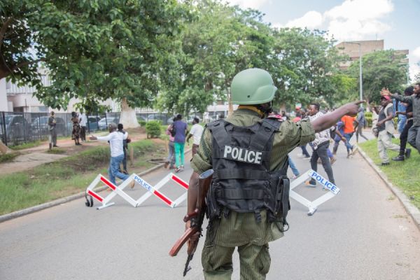 A police officer gestures towards protesters demonstrating against the arrest opposition leader Hakainde Hichilema in Lusaka on December 23 2020jpg
