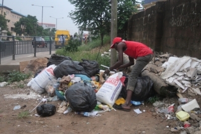 Daily life in Nigeria after coronavirus lockdown relaxation: a scavenger picks scrap in Lagos. Press Association