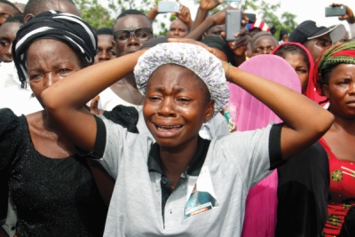 Relatives cry as they mourn during a funeral service for 17 worshippers and two priests, who were allegedly killed by Fulani herdsmen