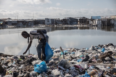 A man sifts through rubbish looking for things he can sell in West Point, Monrovia. West Point is Liberia&#039;s largest urban slum, home to a community of roughly 75,000 people.