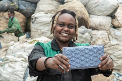 Nzambi poses with one of the recycled plastic blocks.