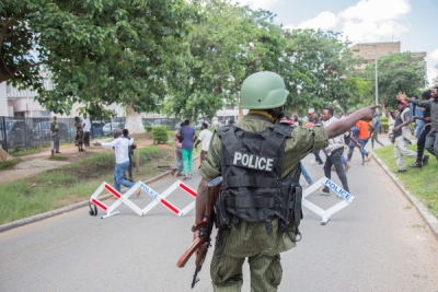 A police officer gestures towards protesters demonstrating against the arrest opposition leader Hakainde Hichilema in Lusaka on December 23, 2020. Getty.